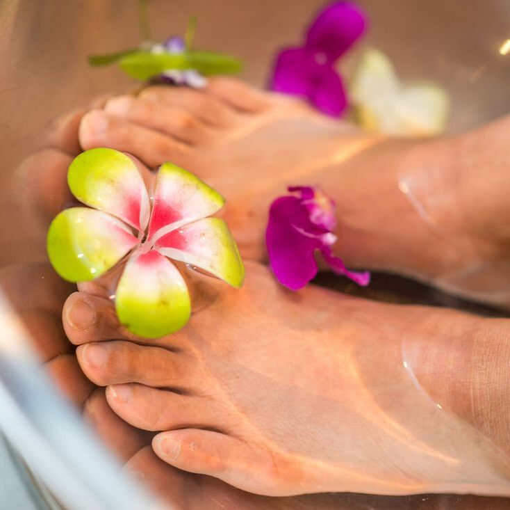 Feet soaking in flowers and foot bath